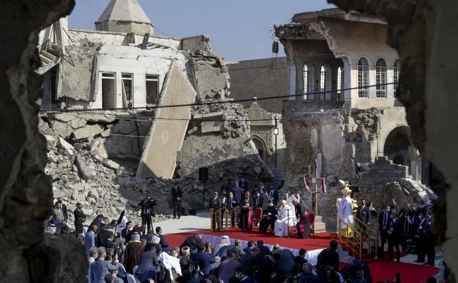 Pope Francis, surrounded by shells of destroyed churches, leads a prayer for the victims of war at Hosh al-Bieaa Church Square, in Mosul, Iraq, once the de-facto capital of IS, on Sunday, 7 March, 2021. The long 2014-2017 war to drive IS out left ransacked homes and charred or pulverized buildings around the north of Iraq, all sites Francis visited. Photo by The Associated Press/Andrew Medichini Pope Francis, surrounded by shells of destroyed churches, leads a prayer for the victims of war at Hosh al-Bieaa Church Square, in Mosul, Iraq, once the de-facto capital of IS, on Sunday, 7 March, 2021. The long 2014-2017 war to drive IS out left ransacked homes and charred or pulverized buildings around the north of Iraq, all sites Francis visited. Photo by The Associated Press/Andrew Medichini