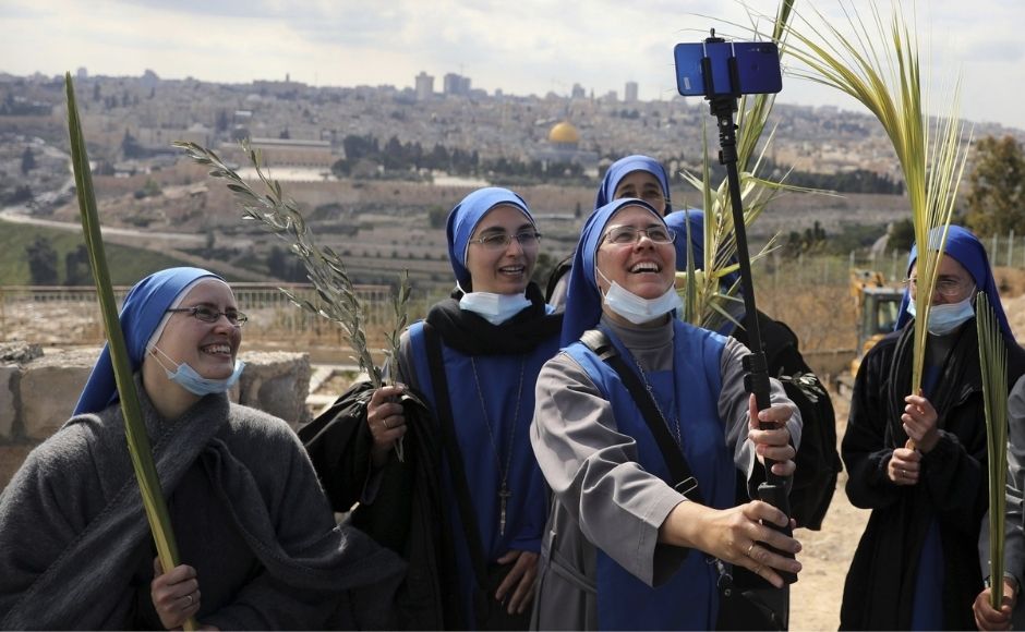 In Israel, beaming nuns took a group selfie atop the Mount of Olives with their masks down below their chins. A year after pandemic restrictions halted mass gatherings, the country has undertaken an aggressive vaccination campaign allowing many aspects of normal life to return. In the picture: Nuns pose for a selfie as they mark Palm Sunday on the Mount of Olives in Jerusalem, on Sunday, 28 March, 2021. A year after coronavirus restrictions halted mass gatherings, Christians are celebrating Holy Week together. Photo by The Associated Press/Mahmoud Illean In Israel, beaming nuns took a group selfie atop the Mount of Olives with their masks down below their chins. A year after pandemic restrictions halted mass gatherings, the country has undertaken an aggressive vaccination campaign allowing many aspects of normal life to return. In the picture: Nuns pose for a selfie as they mark Palm Sunday on the Mount of Olives in Jerusalem, on Sunday, 28 March, 2021. A year after coronavirus restrictions halted mass gatherings, Christians are celebrating Holy Week together. Photo by The Associated Press/Mahmoud Illean