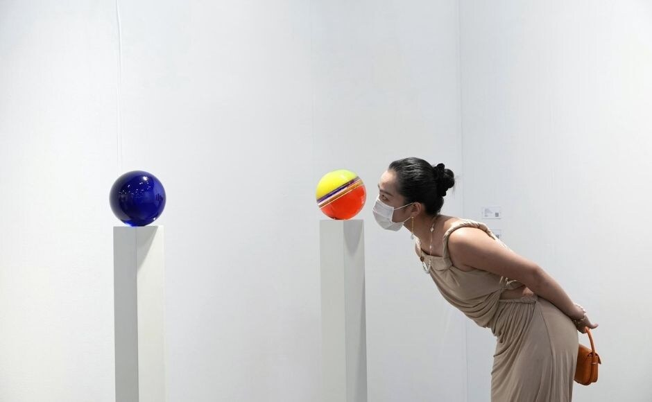 A visitor wearing face mask takes a close look at an artwork "Untitled, 2019" created by American visual artist Helen Pashgian at Art Basel in Hong Kong on Wednesday, 19 May, 2021. Photo via The Associated Press/Vincent Yu A visitor wearing face mask takes a close look at an artwork "Untitled, 2019" created by American visual artist Helen Pashgian at Art Basel in Hong Kong on Wednesday, 19 May, 2021. Photo via The Associated Press/Vincent Yu