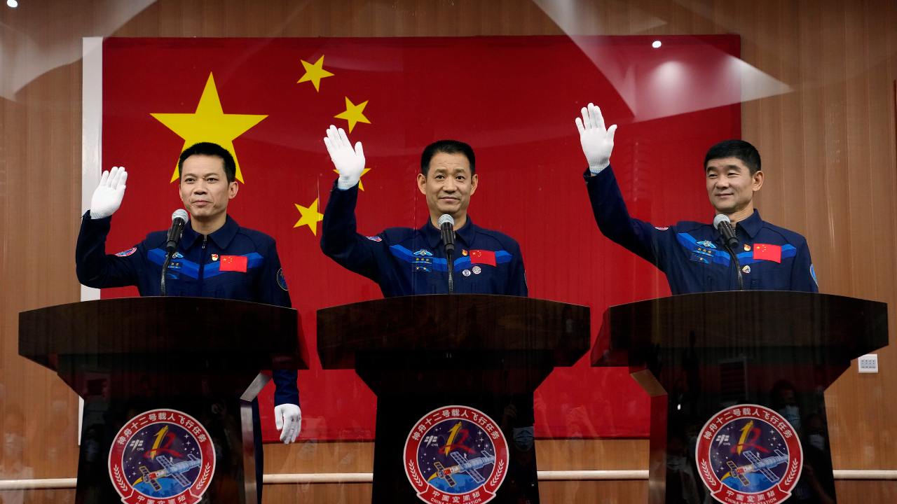 Chinese astronauts, from left, Tang Hongbo, Nie Haisheng, and Liu Boming wave during a press conference at the Jiuquan Satellite Launch Center ahead of the Shenzhou-12 launch from Jiuquan in northwestern China, Wednesday, 16 June  2021. Image credit: AP Photo/Ng Han Guan