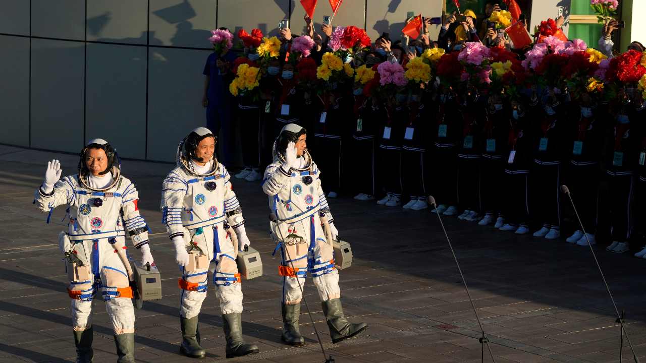 Chinese astronauts, from left, Tang Hongbo, Nie Haisheng, and Liu Boming wave as they prepare to board for liftoff at the Jiuquan Satellite Launch Center in Jiuquan in northwestern China, Thursday, June 17, 2021. China plans on Thursday to launch three astronauts onboard the Shenzhou-12 spaceship who will be the first crew members to live on China's new orbiting space station Tianhe, or Heavenly Harmony. (AP Photo/Ng Han Guan)