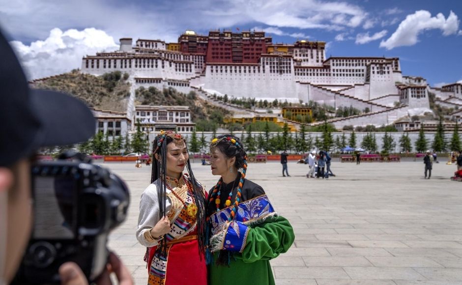 Tourism is booming in Tibet as more Chinese travel in-country because of the coronavirus pandemic, posing risks to the region’s fragile environment and historic sites. | In the picture: Chinese tourists in Tibetan dress pose for a photo at a square near the Potala Palace in Lhasa in western China's Tibet Autonomous Region, on Tuesday, 1 June, 2021. Photo via The Associated Press/Mark Schiefelbein Tourism is booming in Tibet as more Chinese travel in-country because of the coronavirus pandemic, posing risks to the region’s fragile environment and historic sites. | In the picture: Chinese tourists in Tibetan dress pose for a photo at a square near the Potala Palace in Lhasa in western China's Tibet Autonomous Region, on Tuesday, 1 June, 2021. Photo via The Associated Press/Mark Schiefelbein