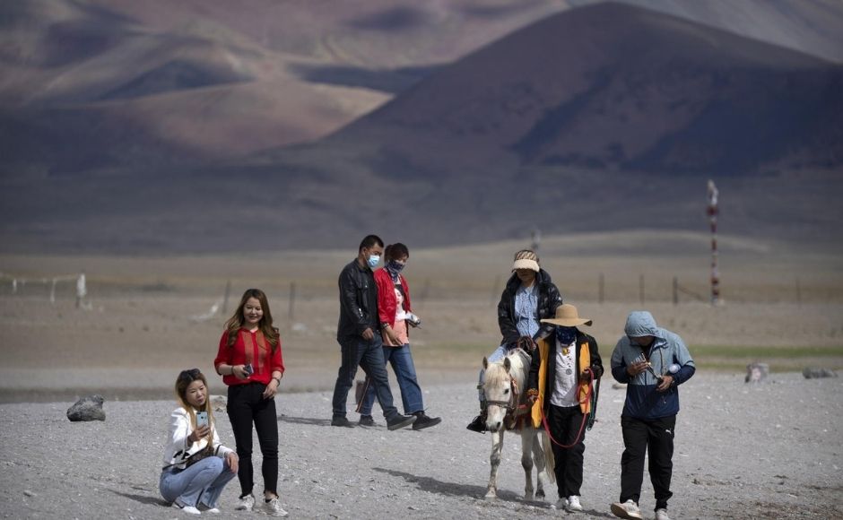 Tourists are drawn to the “mystique and myth of Tibet as a remote snow-bound land,” said Travis Klingberg, a cultural geographer at NYU Shanghai. “But Tibet has become a place of beautiful natural landscapes meaningful to the Chinese nation.” | In the picture: Tourists walk along the lakeshore and ride a pony in Namtso in western China's Tibet Autonomous Region, on Wednesday, 2 June, 2021. Photo via The Associated Press/Mark Schiefelbein Tourists are drawn to the “mystique and myth of Tibet as a remote snow-bound land,” said Travis Klingberg, a cultural geographer at NYU Shanghai. “But Tibet has become a place of beautiful natural landscapes meaningful to the Chinese nation.” | In the picture: Tourists walk along the lakeshore and ride a pony in Namtso in western China's Tibet Autonomous Region, on Wednesday, 2 June, 2021. Photo via The Associated Press/Mark Schiefelbein