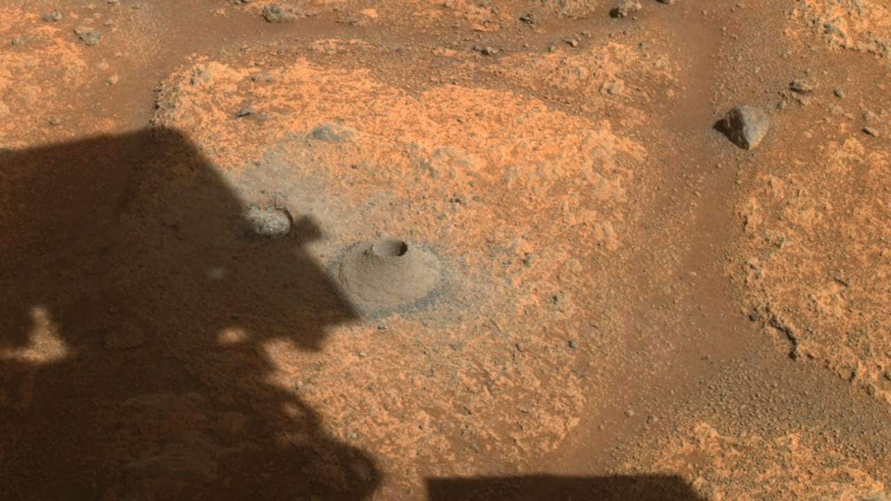 This image taken by one the hazard cameras aboard NASA’s Perseverance rover on Aug. 6, 2021, shows the hole drilled in what the rover’s science team calls a “paver rock” in preparation for the mission’s first attempt to collect a sample from Mars. Image credits: NASA/JPL-Caltech