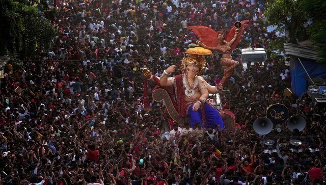 Huge crowds gather around a Ganesh idol in Mumbai. For the last two years, owing to COVID restrictions the erstwhile Uddhav Thackeray government restricted the height of idols to four feet. However, this year, Chief Minister Eknath Shinde removed height restrictions and has also allowed processions. AP Huge crowds gather around a Ganesh idol in Mumbai. For the last two years, owing to COVID restrictions the erstwhile Uddhav Thackeray government restricted the height of idols to four feet. However, this year, Chief Minister Eknath Shinde removed height restrictions and has also allowed processions. AP