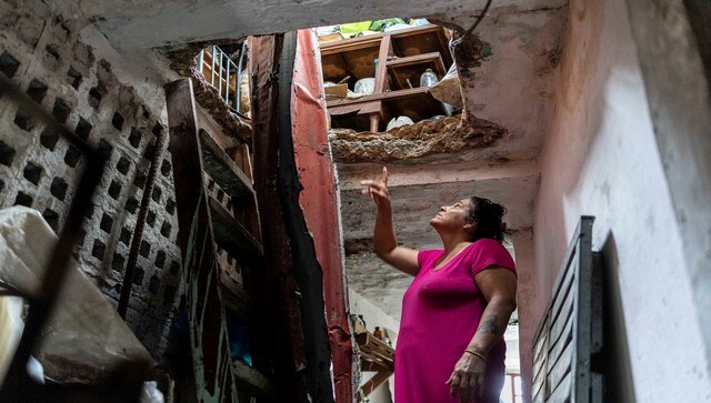 A woman assesses a damaged roof in her house caused by Hurricane Ian. Two people were reported dead while several buildings were left damaged. AP A woman assesses a damaged roof in her house caused by Hurricane Ian. Two people were reported dead while several buildings were left damaged. AP