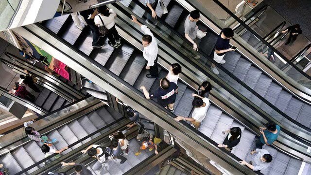 Watch: Woman knocked off escalator after being hit by falling suitcase
