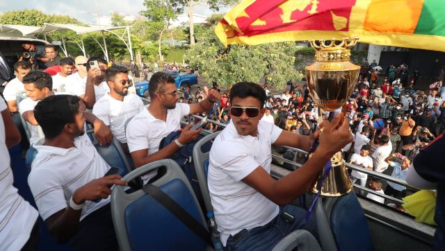 Sri Lanka’s Maheesh Theekshana hoists the Asia Cup trophy during the open-top bus parade. Image: @OfficialSLC