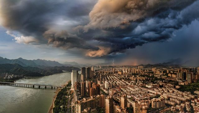 Sunny and Rainy: In the picture, dark clouds from the southeast and the sunset light in the northwest create a great contrast. The scene is very intense. As the drone had just landed on the ground, it started pouring rain. Image Courtesy: Donghui Chen Sunny and Rainy: In the picture, dark clouds from the southeast and the sunset light in the northwest create a great contrast. The scene is very intense. As the drone had just landed on the ground, it started pouring rain. Image Courtesy: Donghui Chen