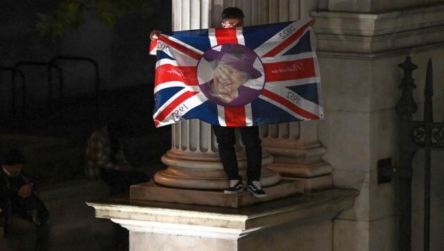 A member of the public holds a Union Jack flag and stands on a corner of Marble Arch in London. Once the Queen’s coffin reaches Westminster, well-wishers will be able to pay their respects and the lying in state will continue until 19 September. AFP A member of the public holds a Union Jack flag and stands on a corner of Marble Arch in London. Once the Queen’s coffin reaches Westminster, well-wishers will be able to pay their respects and the lying in state will continue until 19 September. AFP