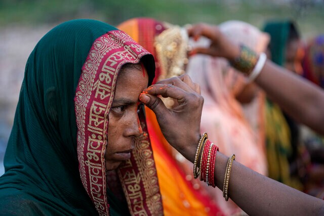 A devotee applies vermillion powder on the forehead of another devotee on the banks of the Tawi River in Jammu, India, 30 October 2022. AP A devotee applies vermillion powder on the forehead of another devotee on the banks of the Tawi River in Jammu, India, 30 October 2022. AP