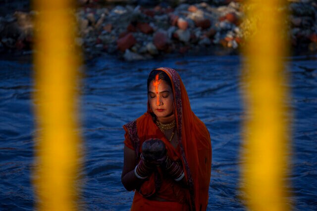 A Nepalese woman offers prayers to the setting Sun at the Bagmati River during the Chhath Puja festival in Kathmandu, Nepal, 30 October 2022. A Nepalese woman offers prayers to the setting Sun at the Bagmati River during the Chhath Puja festival in Kathmandu, Nepal, 30 October 2022.