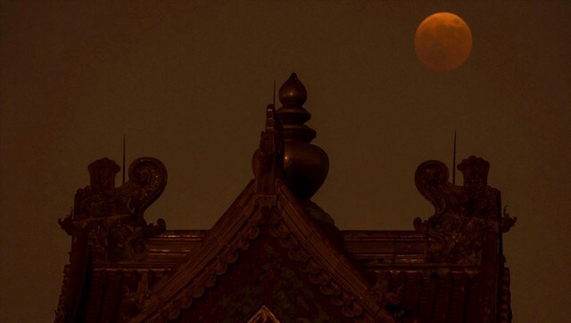 The moon rises behind a corner tower along the outer walls of the Forbidden City during a lunar eclipse in Beijing. The intensity of the red colour on pollution levels, cloud cover and debris in the atmosphere. AP The moon rises behind a corner tower along the outer walls of the Forbidden City during a lunar eclipse in Beijing. The intensity of the red colour on pollution levels, cloud cover and debris in the atmosphere. AP