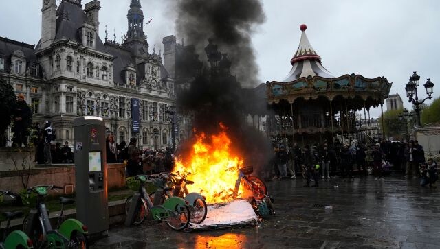 Protesters set bicycles, garbage bins and scooters ablaze in Paris. They also rallied toward the historic Bastille plaza and beyond, with some singing a popular anti-Macron slogan: “We are here, we are here, even if Macron does not want it, we are here”. AP Protesters set bicycles, garbage bins and scooters ablaze in Paris. They also rallied toward the historic Bastille plaza and beyond, with some singing a popular anti-Macron slogan: “We are here, we are here, even if Macron does not want it, we are here”. AP