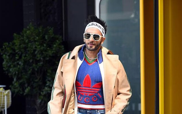 Pop culture icon Ranveer Singh was spotted in New York today, ahead of the highly anticipated Tiffany &amp; Co. event. The paparazzi (Elder Ordonez) caught him near Soho House, dressed in a Gucci x Adidas outfit that looked nothing short of stunning. As always, Ranveer set some fashion goals for his fans, pulling off an oversized trench, knitted sweater, straight-fit jeans, and a pearl necklace like a true fashion icon. It’s safe to say that no one else could have rocked this outfit quite like he did.