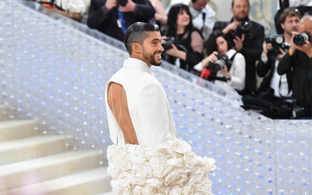 Bad Bunny showed up late in bright white from head to toe with a long cape also adorned with camellias, a Coco Chanel motif embraced by Lagerfeld. Monáe’s look, with a black sparkly leotard underneath, was made by Thom Browne. Bad Bunny showed up late in bright white from head to toe with a long cape also adorned with camellias, a Coco Chanel motif embraced by Lagerfeld. Monáe’s look, with a black sparkly leotard underneath, was made by Thom Browne.