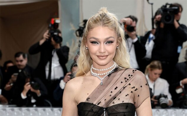 Gigi Hadid wore Givenchy in black with feathers, a drop waist and sheer train in tulle. It took more than 300 hours to make. Kendall Jenner was also in black, sans pants. She wore a sparkly leotard with long sleeves that has pieces doubling as a train. On her feet were kinky, towering black boots, all courtesy of Marc Jacobs. Gigi Hadid wore Givenchy in black with feathers, a drop waist and sheer train in tulle. It took more than 300 hours to make. Kendall Jenner was also in black, sans pants. She wore a sparkly leotard with long sleeves that has pieces doubling as a train. On her feet were kinky, towering black boots, all courtesy of Marc Jacobs.