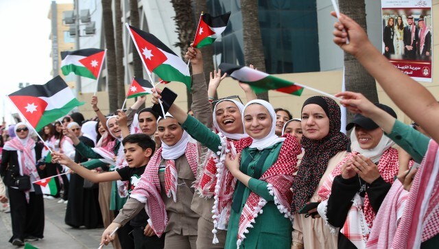 Jordanians wave the national flags in anticipation of the royal motorcade in Amman, Jordan just ahead of Crown Prince Hassan and saudiSaudi architect Rajwa Alseif’s wedding. Jordanians from all walks of life shared an infectious excitement about the union. The wedding fever had been building for weeks. AP