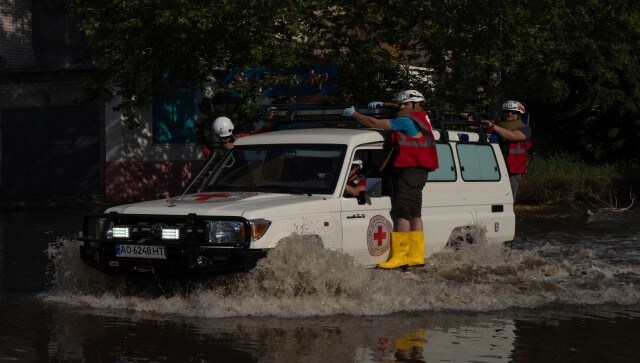 Red Cross workers drive along a street in Kherson, Ukraine, Tuesday, which was flooded after the Kakhovka dam was blown up overnight. It could take days to know the real toll and damage. AP