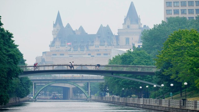 People make their way over the Rideau Canal in Ottawa as smoke from wildfires fills the air. The smoke was so thick in Canada’s capital, Ottawa, that office towers just across the Ottawa River were barely visible. AP People make their way over the Rideau Canal in Ottawa as smoke from wildfires fills the air. The smoke was so thick in Canada’s capital, Ottawa, that office towers just across the Ottawa River were barely visible. AP