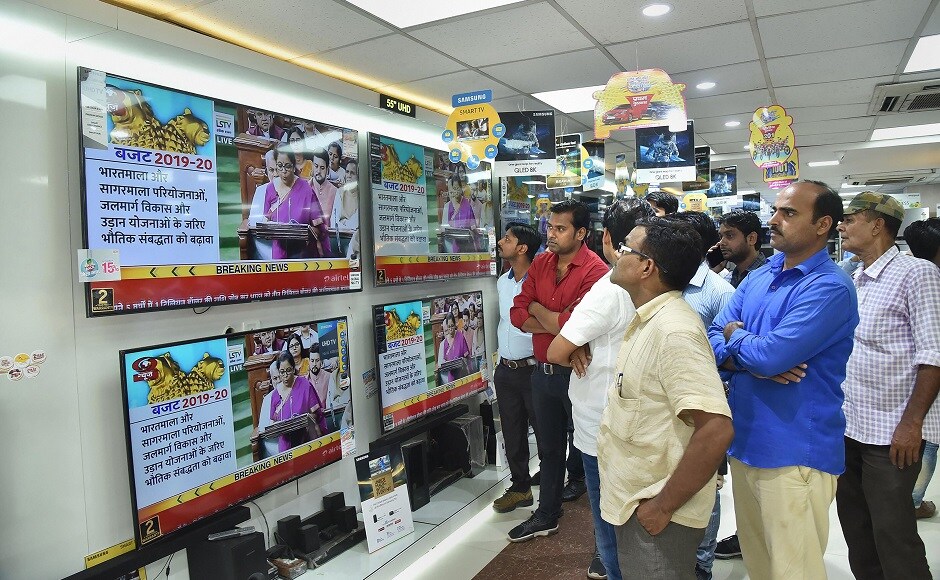 People gather in a shop to watch the live telecast of the Union Budget. Tabling the Modi 2.0 government's maiden budget, Sitharaman said that steps were taken to boost infrastructure in sectors like roads, waterways, metro, and rail. She also emphasised on the measures for a self-reliant aviation industry. PTI People gather in a shop to watch the live telecast of the Union Budget. Tabling the Modi 2.0 government's maiden budget, Sitharaman said that steps were taken to boost infrastructure in sectors like roads, waterways, metro, and rail. She also emphasised on the measures for a self-reliant aviation industry. PTI