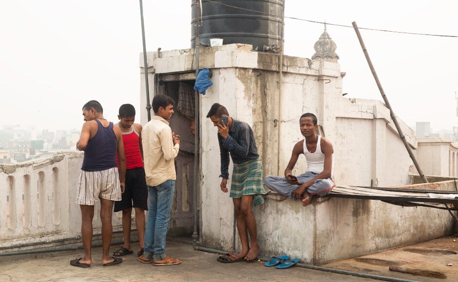 A group of migrant workers employed in the spice market take a break on a roof in Khari Baoli, Old Delhi. None of them are given masks during work hours. A group of migrant workers employed in the spice market take a break on a roof in Khari Baoli, Old Delhi. None of them are given masks during work hours.