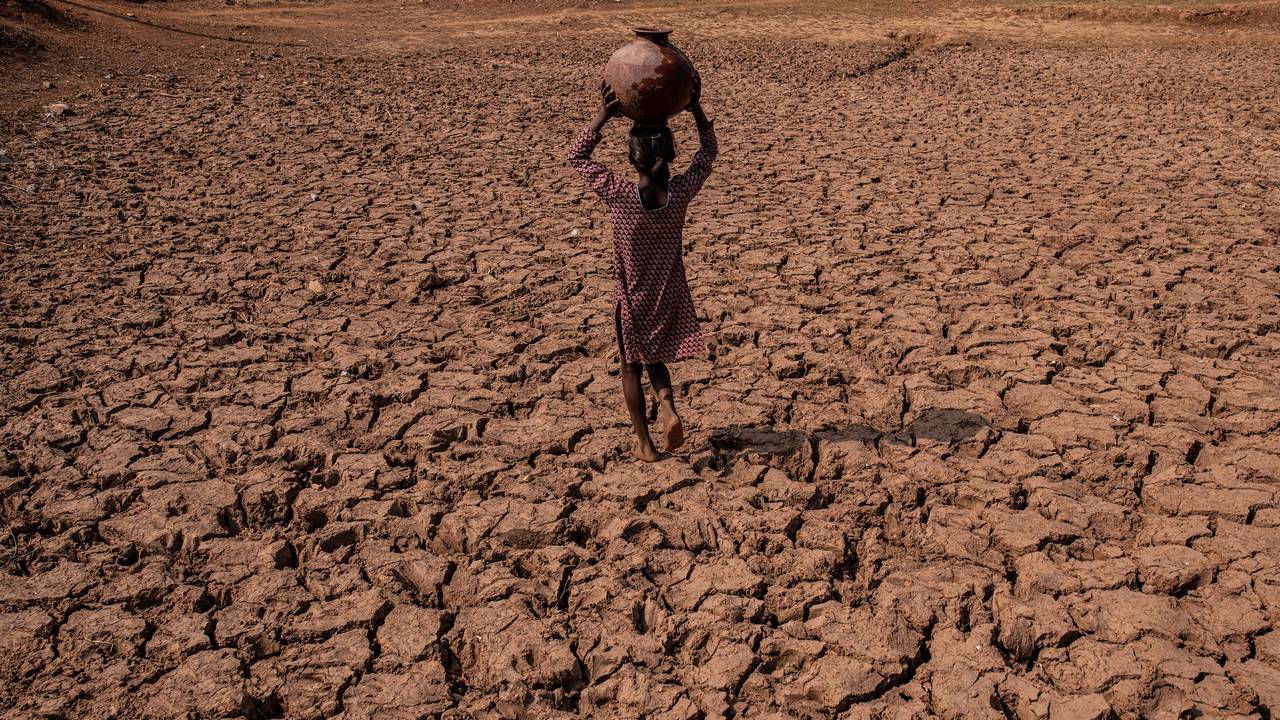 A girl walks across the cracked dry ground in the village of Charam in Uttar Pradesh, India, June 14, 2019. By Bryan Denton c.2019 The New York Times