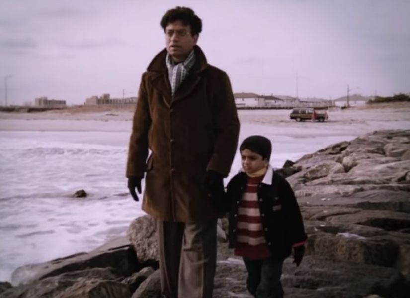 Ashoke awkwardly weighed down by the heavy winter clothing, accompanied by a baby Gogol