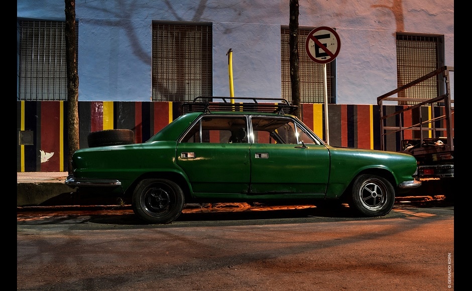 In the federal district of Buenos Aires (Capital Federal) there aren’t many vintage cars left parked on the street and out in the open. It is like an archaeological exploration that must be faced without destination, attentive to any surprise that may come around a corner. | In the picture: Torino, Barracas neighbourhood, 2019. This Torino is a four-door sedan. Korn discovered it in an area where there are still many colonial-style houses and old warehouses. The school in the background gives the perfect framework for this colourful ensemble. In the federal district of Buenos Aires (Capital Federal) there aren’t many vintage cars left parked on the street and out in the open. It is like an archaeological exploration that must be faced without destination, attentive to any surprise that may come around a corner. | In the picture: Torino, Barracas neighbourhood, 2019. This Torino is a four-door sedan. Korn discovered it in an area where there are still many colonial-style houses and old warehouses. The school in the background gives the perfect framework for this colourful ensemble.