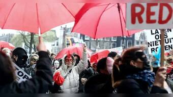 What is the controversy over Amsterdam mayor's plan to move legal prostitution from city's historic red light district?