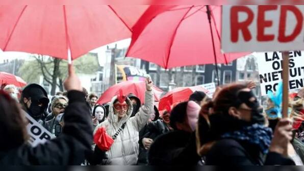 What is the controversy over Amsterdam mayor's plan to move legal prostitution from city's historic red light district?