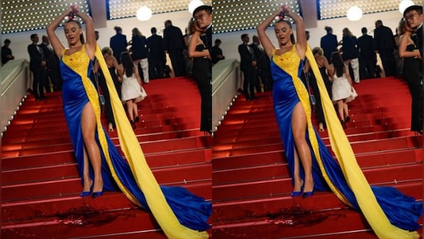 Woman draped in colours of the Ukrainian flag pours fake blood on herself at Cannes red carpet