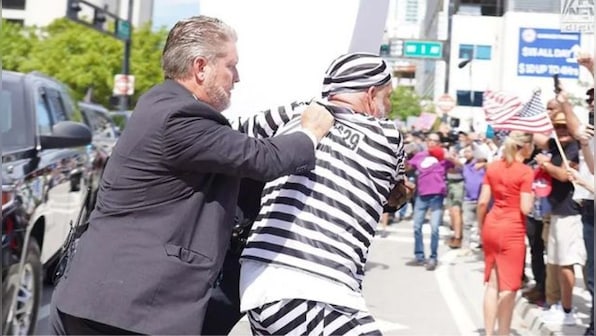 WATCH: Protestor in prison costume jumps in front of Trump’s car outside Miami courthouse