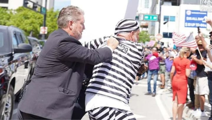 WATCH: Protestor in prison costume jumps in front of Trump’s car outside Miami courthouse