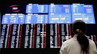 A woman looks at an electronic board showing Japan's stock price index at the Tokyo Stock Exchange in Tokyo. Reuters