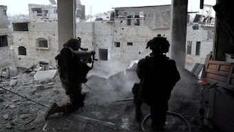 Israeli soldiers fire during an operation against Palestinian Islamist group Hamas, in a location given as Gaza in this handout image released on 16 November, 2023. IDF/REUTERS