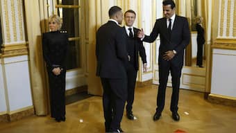 Qatar's Emir Sheikh Tamim bin Hamad Al Thani, right, French President Emmanuel Macron, center, meet PSG's Kylian Mbappe. AP
