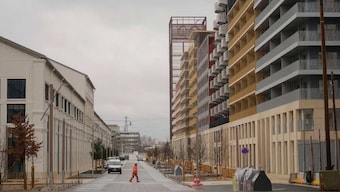 A worker walks in a street of the Olympic village, in Saint-Denis, north of Paris. AP