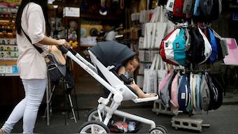 A woman pushing her baby in a stroller shops in the Hongdae area of Seoul. Reuters file