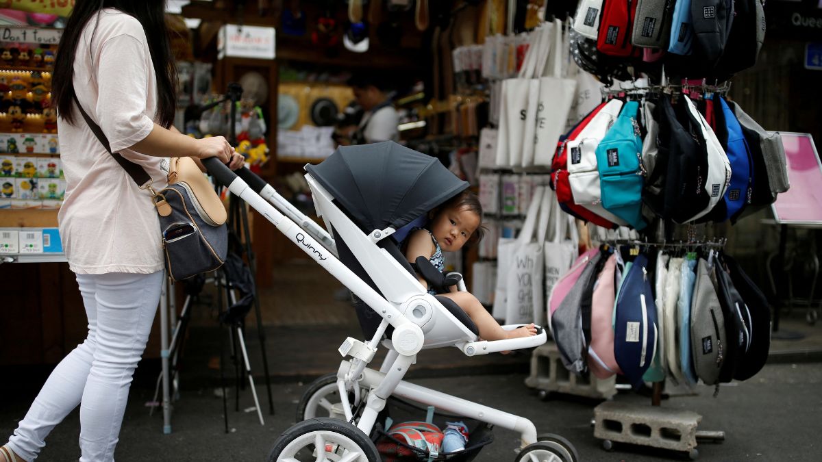 A woman pushing her baby in a stroller shops in the Hongdae area of Seoul. Reuters file A woman pushing her baby in a stroller shops in the Hongdae area of Seoul. Reuters file