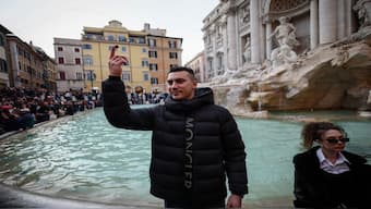 A visitor throws a coin into the Trevi Fountain in Rome, Italy. Reuters 