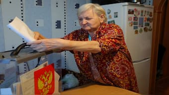 A woman casts a ballot into a mobile ballot box at her home in Russia as members of an electoral commission visit local residents during the early voting in Russia's presidential election in the settlement of Dubovoe in the Belgorod Region, Russia. Reuters 