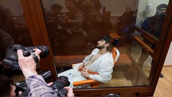 Muhammadsobir Fayzov, a suspect in the shooting attack at the Crocus City Hall concert venue, sits in a medical transport chair behind a glass wall of an enclosure for defendants before a court hearing at the Basmanny district court in Moscow, Russia. Reuters 