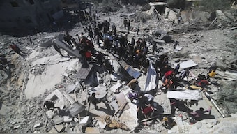 Palestinians look at a residential building destroyed in an Israeli strike in Rafah, Gaza Strip. AP