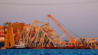 Cranes stand by as the wreckage of the Francis Scott Key Bridge rests on the container ship Dali, in Baltimore. AP