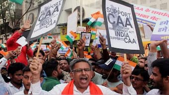 People hold placards and shout slogans in favor of the Citizenship Amendment Act (CAA) in Mumbai. FILE/ANI.