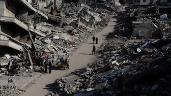 Palestinians walk through the destruction from the Israeli offensive in Jabaliya refugee camp in the Gaza Strip on Thursday, Feb. 29, 2024. - AP