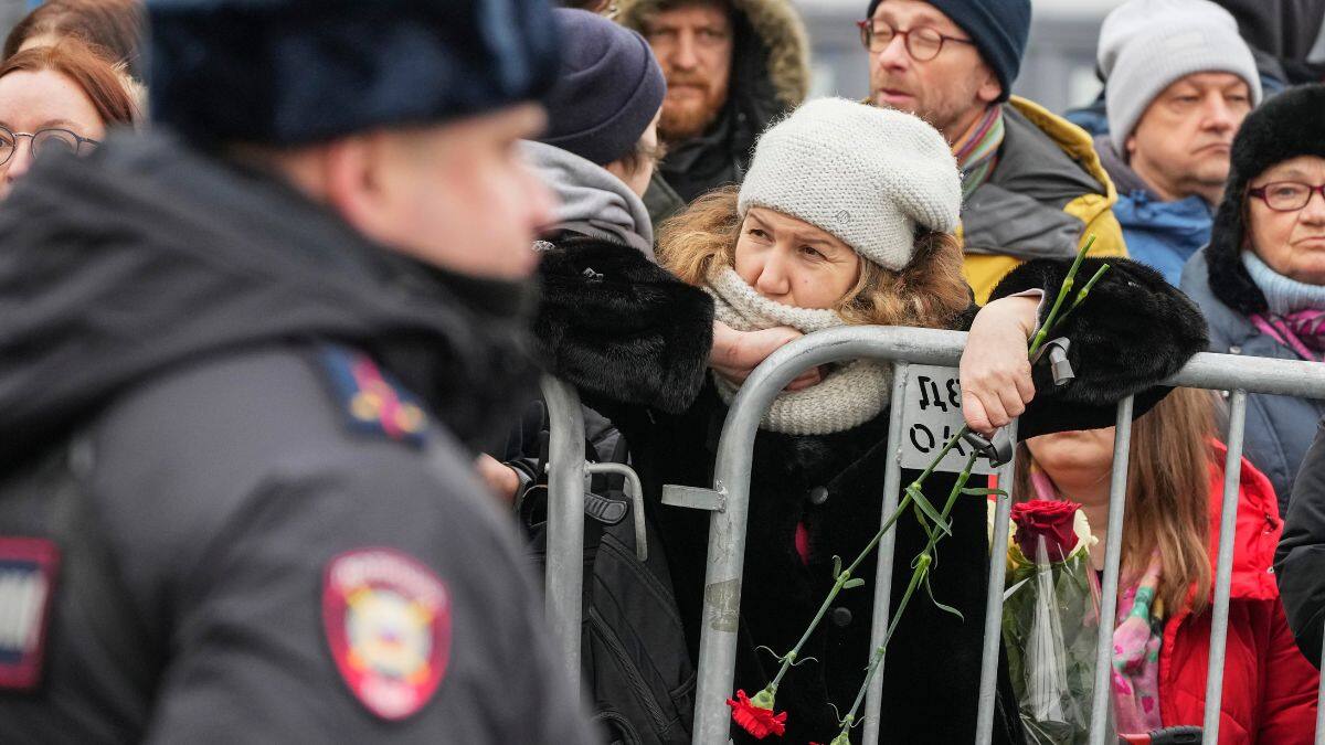 A Police officer guards as people gather near the Church of the Icon of the Mother of God Soothe My Sorrows, in Moscow, Russia, Friday, March 1, 2024.