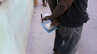 A man holds his ration book known as a “libreta,” at a government-run store in Havana, Cuba. AP