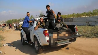 The picture shows the half-naked body of German-Israeli Shani Louk alongside gun-wielding Hamas terrorists. Image Courtesy: @AvivaKlompas/X
